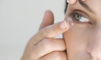 Centro Óptico Ronda Triana mujer colocándose lente de contacto